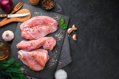 Dereotlu ve sarımsaklı, koyu arkaplanda taze hindi filetosu. Kopyalamak için alanı olan mutfak arkaplanı.