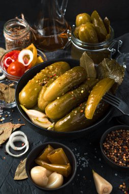 Siyah arka planda salatalık turşusuyla hayat. Yan görünüm, dikey.