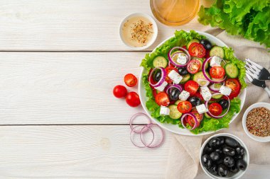 Beyaz ahşap arka planda taze sebze salatası ve malzemeler. Düzgün beslenme kavramı.