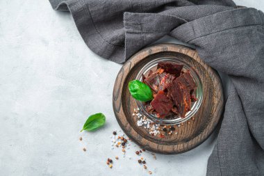 Gri arka planda baharat ve fesleğenli doğal etten yapılan aperatif. Üst manzara, yatay. Kurutulmuş et.