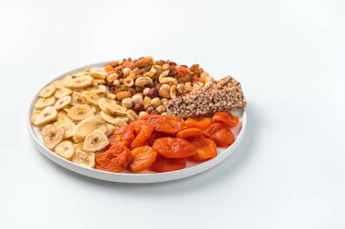 Beyaz arka planda düz tabağı olan doğal, sağlıklı tatlılar. Yan görünüm, boşluk kopyala.