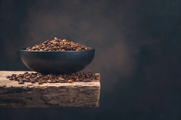 Czarny Ceramiczny Talerz Ziarnem Kawy Drewnianej Desce Brązowym Tle Widok — Zdjęcie stockowe
