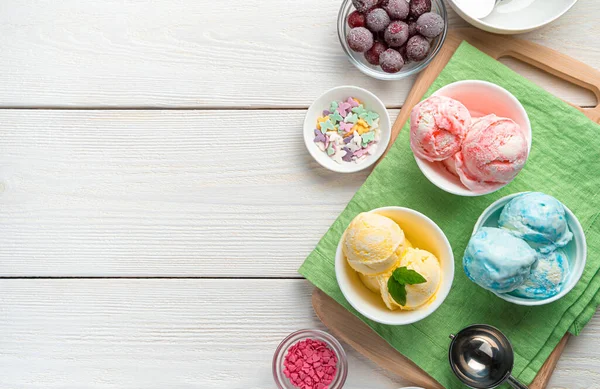 Fruit ice cream of three types on a salad napkin on a white background. Top view, copy space.