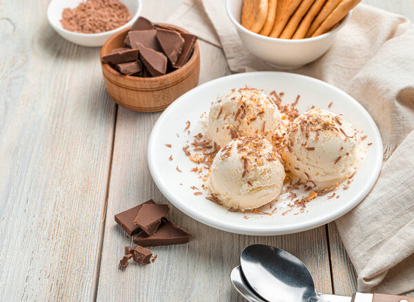 Creamy dessert, ice cream balls with chocolate on a light background. Close-up, copy space.