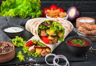 Siyah arka planda ızgara et ve sebzeli Türk donör kebabı. Sulu shawarma, fast food. Yan görünüm, yakın plan.