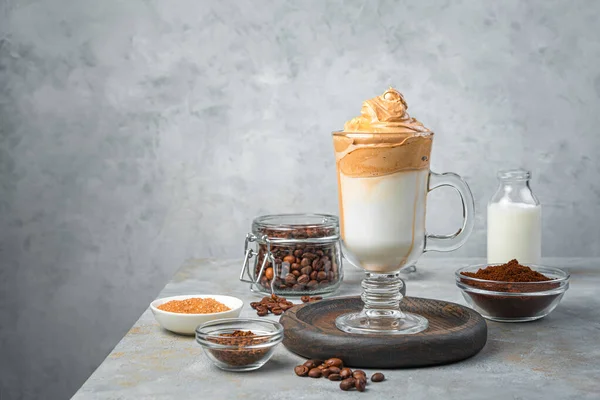 Korean drink with whipped coffee foam-dalgona coffee on a gray background. Side view, copy space.