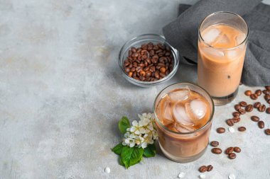 Gri arka planda buzlu kahve. Kopyalanacak yer de var. İki bardak, ferahlatıcı sütlü kahve..