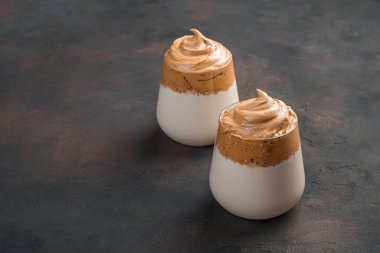 Kahverengi arka planda iki bardak sütlü kahve tatlısı. Yan görünüm, boşluk kopyala.