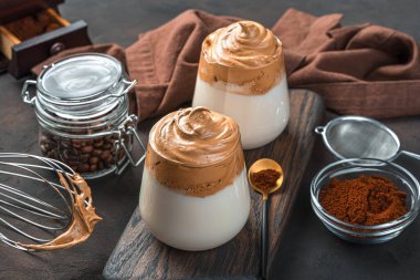 Kahverengi arka planda iki bardak dalgona kahvesi. Geleneksel Kore içkisi. Boşluğu kopyala.