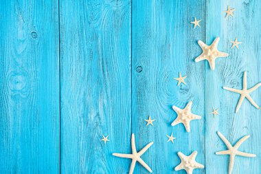 Mavi arka planda farklı şekillerde denizyıldızları. Yaz arkaplanı.