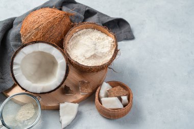 Hindistan cevizi unu ve gri arka planda hindistan cevizi. Yan görünüm, boşluk kopyala.