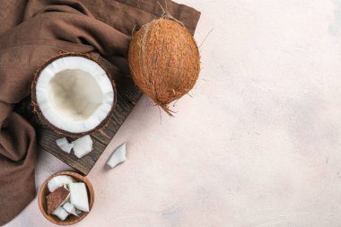 Açık bir hindistan cevizi açık pembe arka planda tahta bir tahta üzerinde.