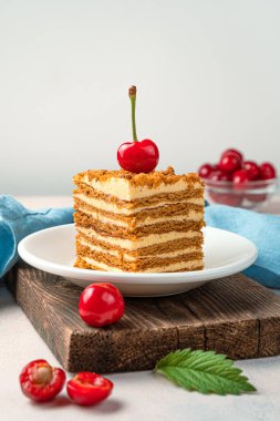 Bal keki ve arka planda taze kirazlar. Kopyalanacak yer de var. Ev yapımı tatlı. Dikey görünüm.