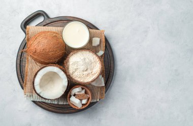 Hindistan cevizi sütü, un ve gri arka planda hindistan cevizi. Üst görünüm, alanı kopyala.