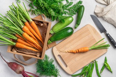 Gri arka planda taze sebzeleri doğramak. Sebze yemeği hazırlama.