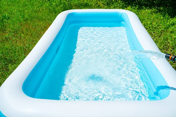 Zwembad onderhoud, het vullen van het zwembad met schoon water. Zomer entertainment. — Stockfoto