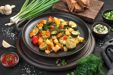 Siyah arka planda sebze yahnisi. Sağlıklı vejetaryen yemekleri. Yatay görünüm, yakın plan.