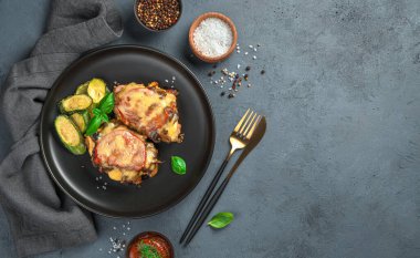 Mantarlı fırında et, domates ve peynirli gri arka planda baharatlar ve keten peçeteyle. Üst görünüm, alanı kopyala.