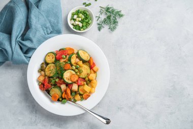 Bir porsiyon sebze yahnisi, kabak, patates, havuç ve bezelye. Vejetaryen, diyet yemekleri.