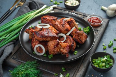 Mavi-gri arka planda taze otlu kızarmış et. Yan görünüm, yakın plan.