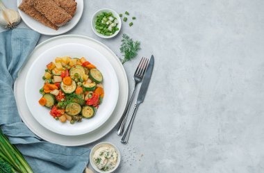 Gri arka planda bir porsiyon kızarmış sebze ve kopyalamak için yer var. Sağlıklı yiyecekler. Üst görünüm.