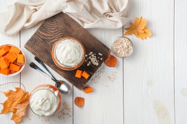 İki porsiyon balkabağı parfe ve hafif arka planda mısır gevreği. Sonbahar, sağlıklı tatlı. Üst görünüm, alanı kopyala.