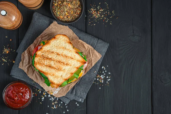 Kızarmış sandviç, sebzeli, jambonlu ve peynirli siyah arka planda.. — Stok fotoğraf