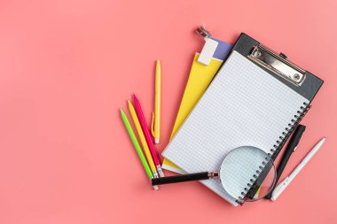 Pembe arka planda okul malzemeleri. Üst görünüm, alanı kopyala.
