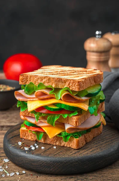 Kahverengi arka planda peynirli, jambonlu ve taze sebzeli duble sandviç.. — Stok fotoğraf