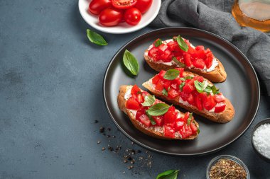 Geleneksel bruschetta domatesli, fesleğenli ve krem peynirli. Yan görüş. İtalyan mezesi..