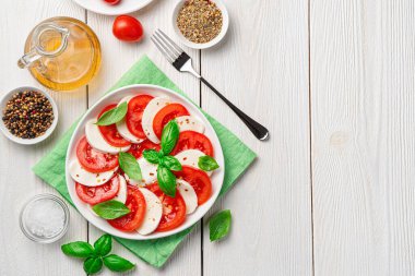 Beyaz arka planda domatesli ve mozzarellalı Caprese salatası. İtalyan yemeği..