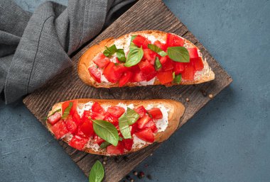 Domatesli kızarmış ekmek, feta ve fesleğen. Geleneksel İtalyan aperatifi, domatesli bruschetta.