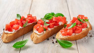 Domatesli, peynirli ve fesleğenli geleneksel bruschetta. İtalyan aperatifi, antipasti..
