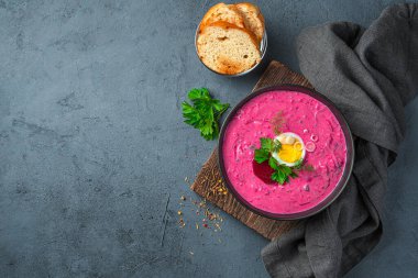 Yumurtalı pancar çorbası, otlar, kefir ve patatesler gri-mavi arka planda. Üst görünüm, alanı kopyala.