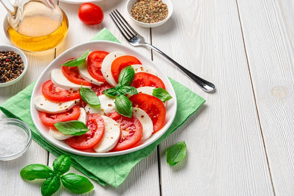健康的な 新鮮なみじん切りトマトで作られたイタリアのカプレーゼサラダ 白のモッツァレラチーズとバジル 木製の背景 横表示 コピーのためのスペース — ストック写真