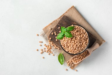 Gri arka planda çiğ, kuru nohut dolu bir kase. Üst görünüm, boşluğu kopyala. Sağlıklı, organik yiyecekler..