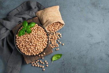 Kabuğu soyulmuş, koyu arkaplanda çiğ bezelyeler. Üst görünüm, alanı kopyala.