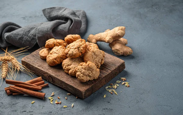 Homemade ginger cookies, ginger and cinnamon on a dark background.