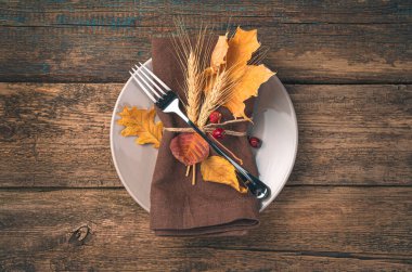 Sonbahar, aşçılık geçmişi. İçinde peçete, çatal ve sonbahar yaprakları olan bir tabak..
