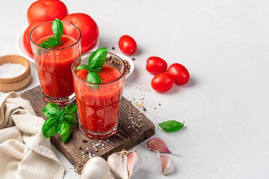 Fesleğenli domates suyu ve hafif arka planda baharatlar. Yan görünüm, kopyalamak için boşluk.