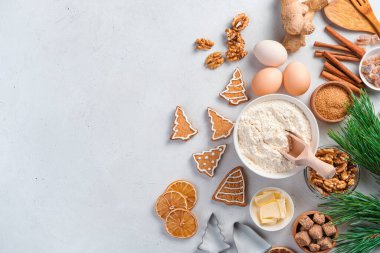 Mutfak şenliği arka planında zencefilli kurabiyeler ve gri arka planda pişirme malzemeleri var. Mutlu Noeller ve mutlu yıllar. Üst görünüm, alanı kopyala.
