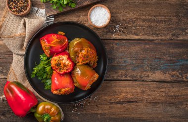 Ahşap bir arka planda et, pirinç ve sebzelerle doldurulmuş biber. Üst görünüm, alanı kopyala.