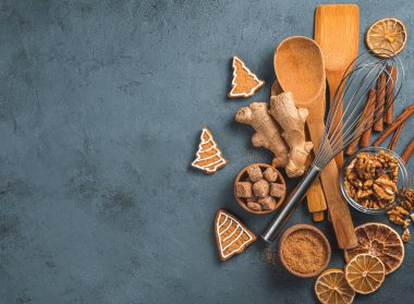 Malzemelerle yemek pişirme, zencefilli kurabiye ve karanlık arka planda yemek pişirme aksesuarları. Noel konsepti, Yeni Yıl.