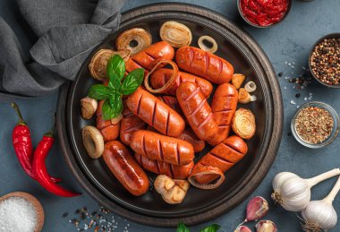 Baharatlı sosis, soğan, sarımsak ve fesleğen ve gri-mavi arka planda. Yakın plan..