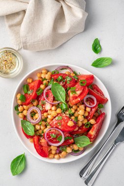 Nohut, domates, fesleğen ve zeytinyağlı sebze salatası. Sağlıklı, vejetaryen yiyecekler. Üst görünüm, dikey.