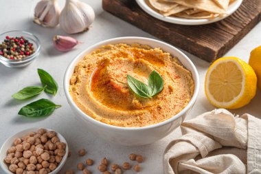 Hafif arka planda zeytinyağı, susam ve limon içeren geleneksel humus..