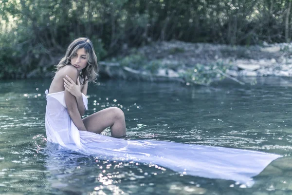 Modelo loira em um rio sob a água com vestido rosa longo — Fotografia de Stock