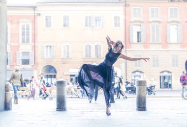 Genç kız sokakta dans ediyor. 