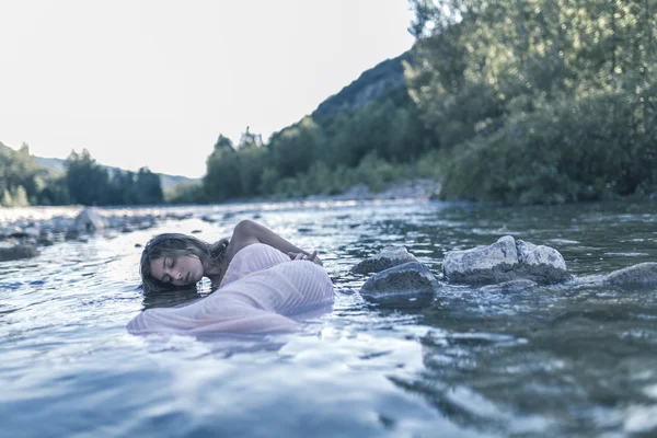 Menina modelo loira com vestido rosa longo em um rio sob a água — Fotografia de Stock