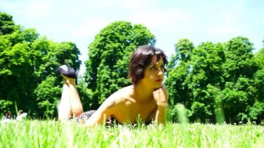 Parma 'daki halk bahçesinde kısa saçlı güzel bir kız yatıyor.